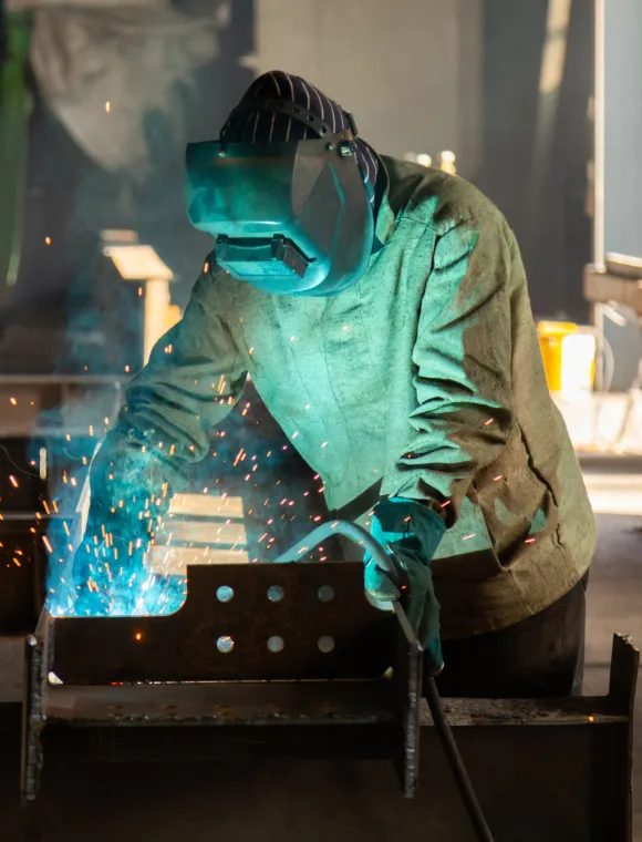 Welder in full suit working on metal project