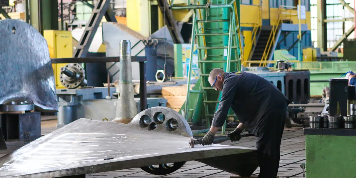 Worker grinding metal wing